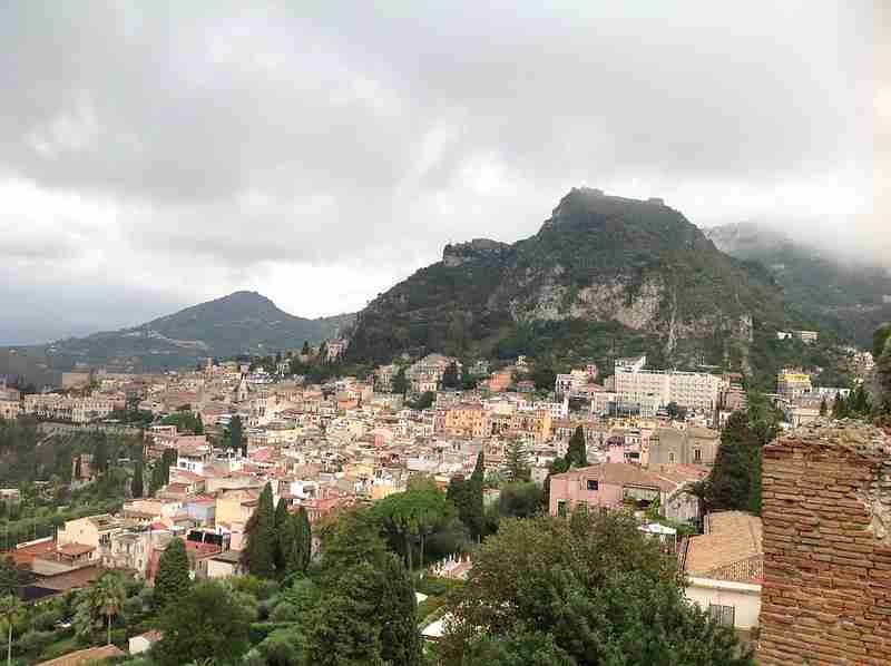 Taormina közel van Cataniához és mindenképp érdemes ide elmenni. Gyönyörű a kilátás és maga a város is egy csoda. A képen a hegyek látszódnak és a város egy része. Balra a tenger és a felhők
