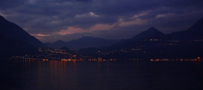 Kép arról, ahogy lemegy a nap a Comói-tónál. Látszódnak a nap utolsó sugarai, a városok fényei. Csodálatos! 